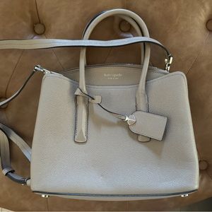 Beige Kate Spade purse with top handles and long crossbody or shoulder strap